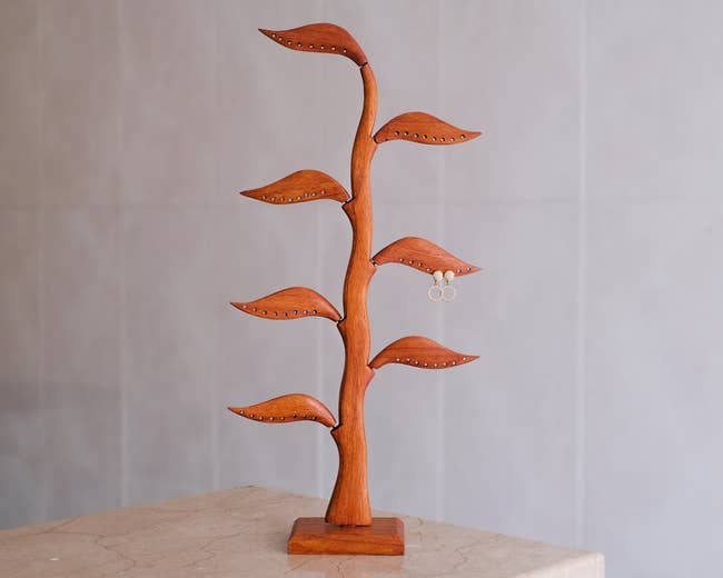 Wooden jewelry stand with multiple branches, designed to hold rings and earrings