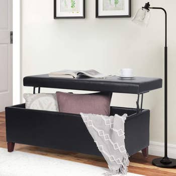 product image of black faux leather lift-top storage ottoman bench