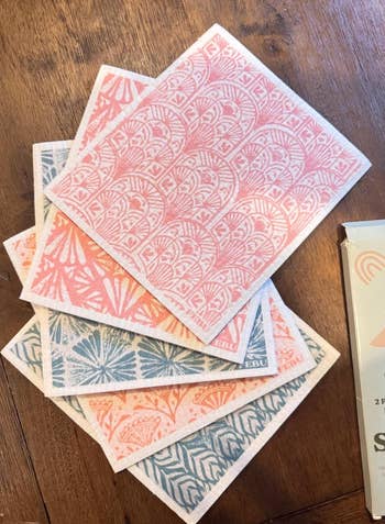 Patterned dishcloths with intricate designs are displayed connected  a woody  table, perfect  for room  cleaning