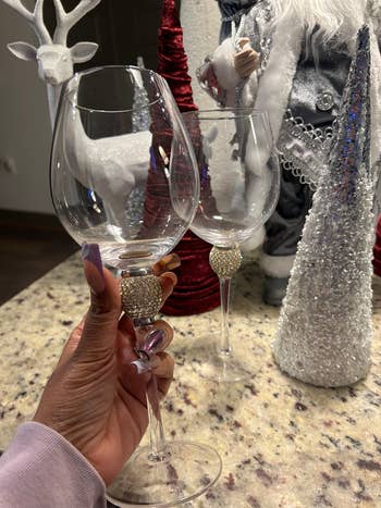 a reviewer holding a wine glass with another in the background