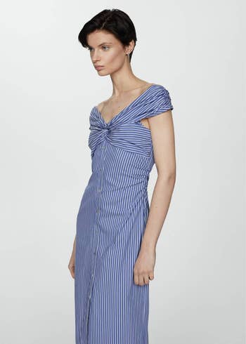 Model in a striped dress with off-shoulder knot detail