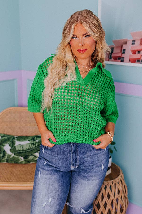 a model posing in the bright green top and denim jeans