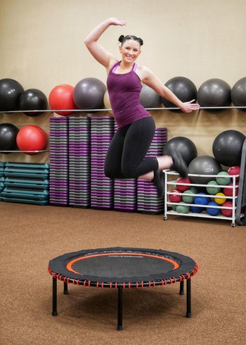 reviewer jumps on same trampoline in orange and black color at a gym