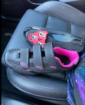 reviewer's pink and black cycling shoes on the passenger seat of a car