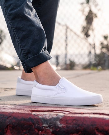 model wearing the white slip ons