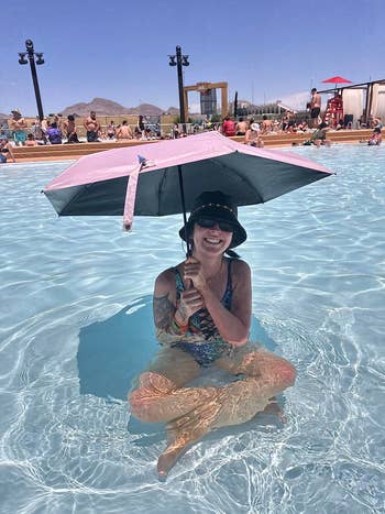 Reviewer sitting successful  a excavation  sitting successful  the shadiness  of a pinkish  parasol 