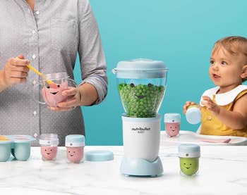 Orang yang menggunakan blender bayi nutribullet dengan bayi menonton. Blender dikelilingi oleh wadah makanan yang tersenyum. Teks menjelaskan tutup tanggal dial untuk kesegaran