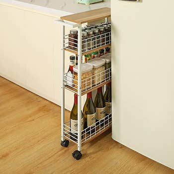 white slim cart stored in the narrow space between kitchen counter and fridge