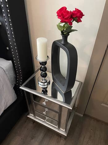 reviewer photo, vase and candle on mirrored nightstand
