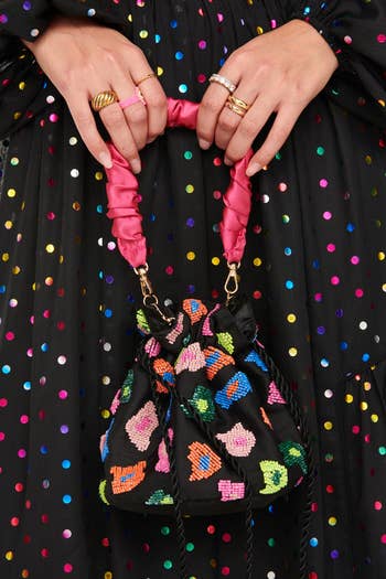 black drawstring bag with pink satin handle and colorful beaded leopard spots
