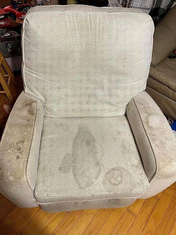 before image of a heavily stained beige armchair