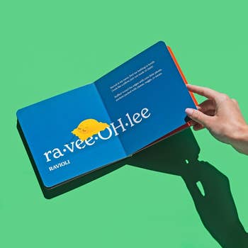 Hand holding a publication  unfastened  to a leafage   featuring a cute ravioli illustration and the phonetic spelling 