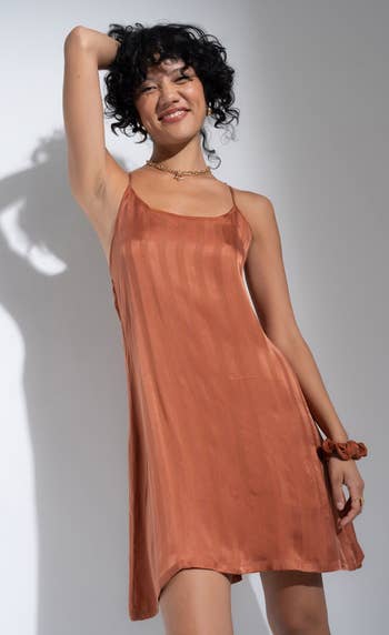 model posing in the orange slip dress