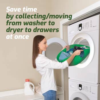 A model lifting clothes out of the dryer with the green carrier 