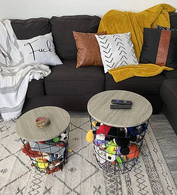 A reviewer's two nesting tables filled with toys by their couch