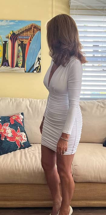 A reviewer wearing the dress in white