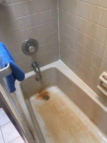 reviewer before photo showing their bathtub looking dirty 