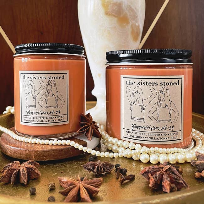two orange peppered citrus candles