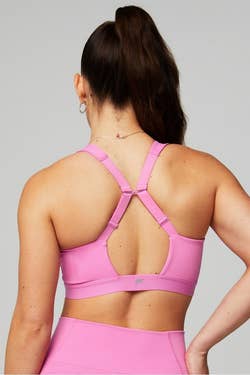 model showcasing the back design of a pink sports bra suitable for active wear