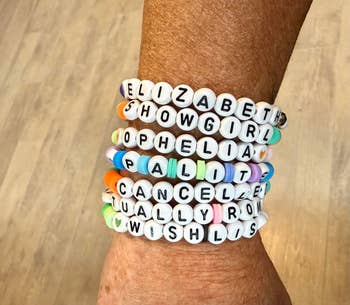 Person wearing beaded bracelets with Taylor Swift songs similar