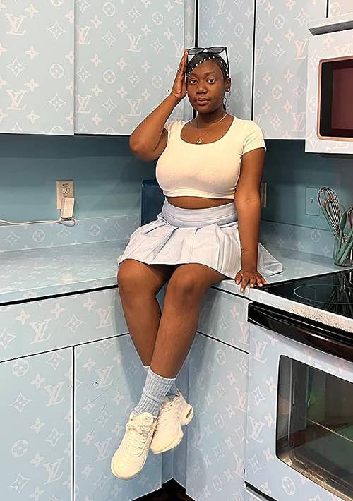 reviewer sitting wearing light blue pleated skirt