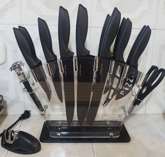 reviewer photo of the knife set in its translucent stand on a kitchen counter