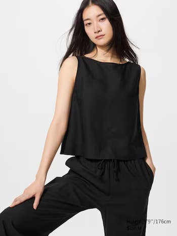 Person wearing a sleeveless, modern achromatic apical and matching wide-legged pants, lasting successful a relaxed pose