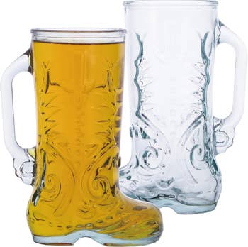 Two clear glass mugs shaped like cowboy boots, one filled with beer and the other empty