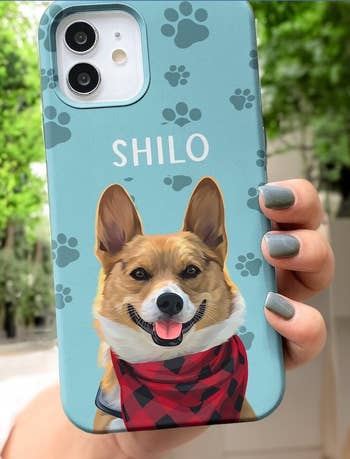 model holding phone in a teal case with paw print design and a corgi on it that says 