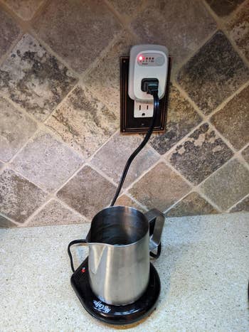 網路行銷 reviewer's mug warmer plugged into the auto shutoff outlet