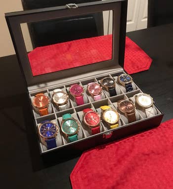 reviewer's black watch box opened to grey red interior storing 12 watches