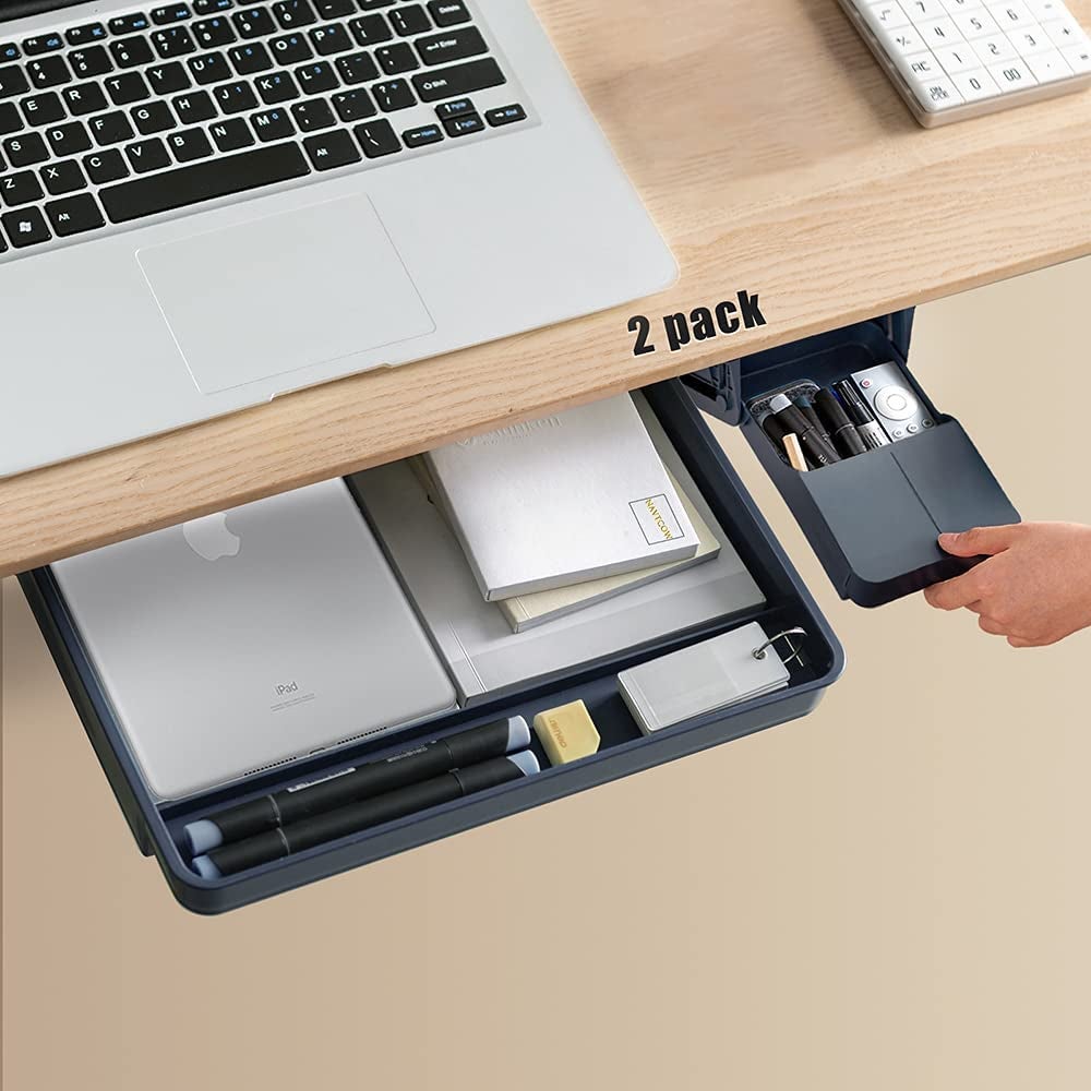 the two drawers sliding out from under a desk containing an iPad and office supplies