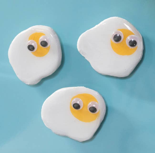 Three polymer clay magnets shaped like a sunny side up egg with googly eyes on it