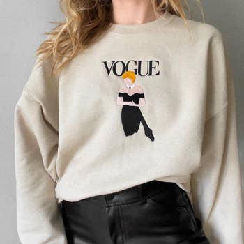 the beige sweatshirt with the same illustration and the words 