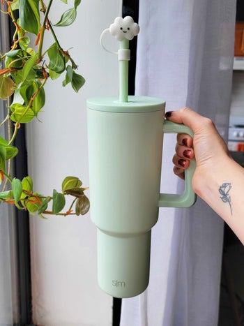 editor holding up the light green tumbler