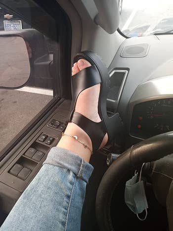 a reviewer wearing the platform sandals in black with jean