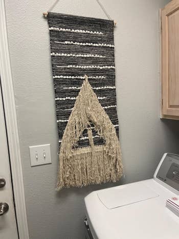 reviewer's gray and beige wall hanging tapestry in a laundry room