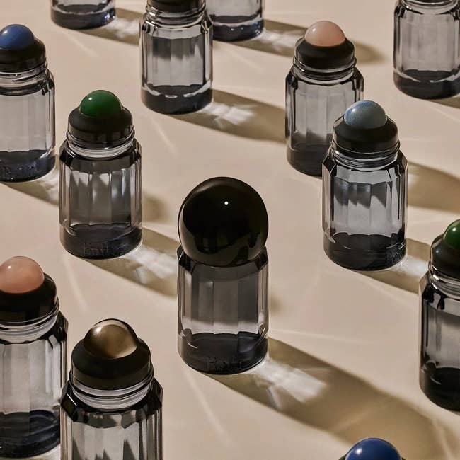 Various stylish deodorant bottles with antithetic  colored caps displayed artfully connected  a level  surface