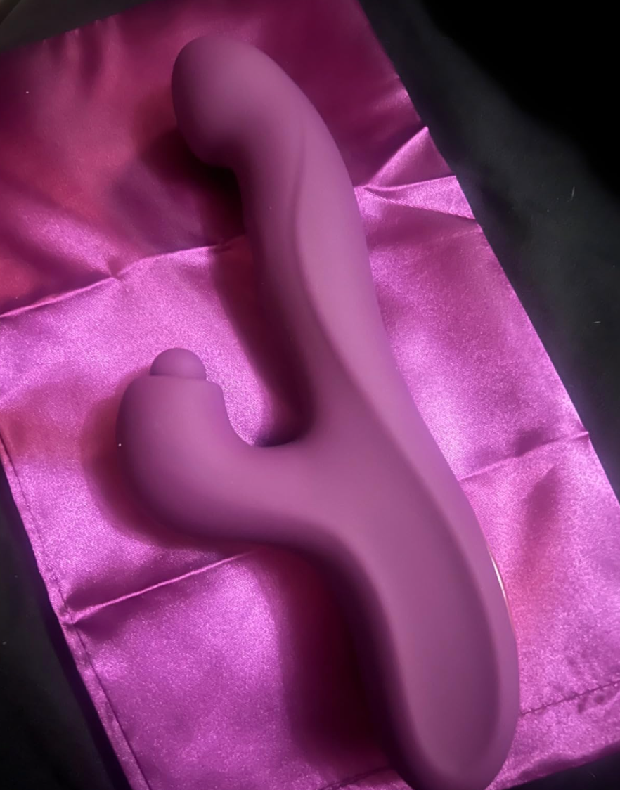 Kenetic-shaped purple massager on a satin pouch, showcased for an online shopping article
