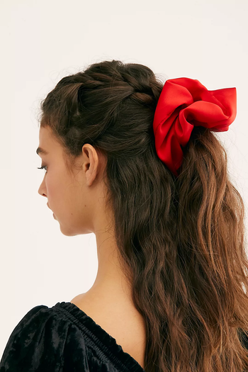 Model with large red scrunchie in their hair 