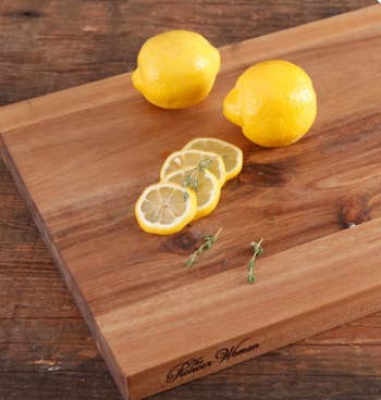 A cutting board with lemons, including lemons slices