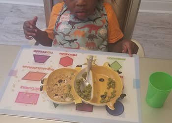 reviewer's photo of their child using the shapes placemat during a meal