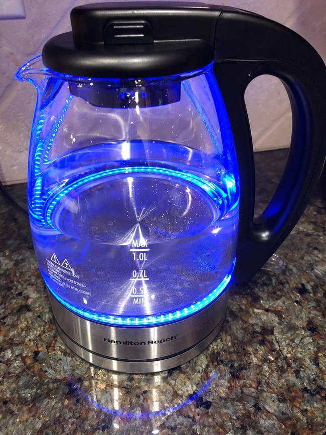 a reviewer photo of the electric kettle on with the blue lights showing