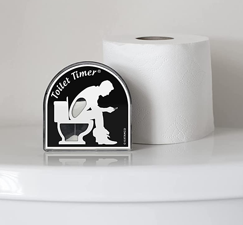 the black toilet timer with an illustration of someone using the bathroom next to a roll of toilet paper