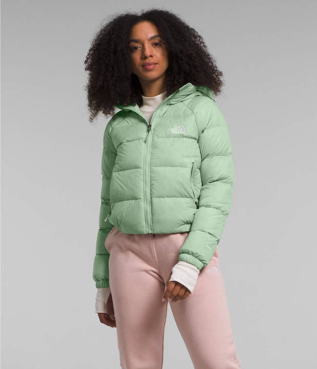 a model poses in the sage color jacket