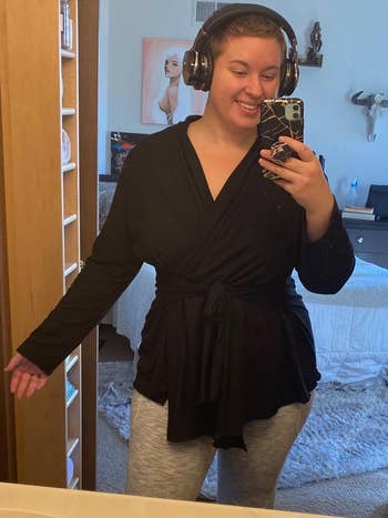 A reviewer taking a mirror selfie while wearing the cardigan in black