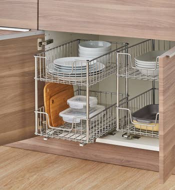 Silver pull out drawer under a cabinet with dishes inside