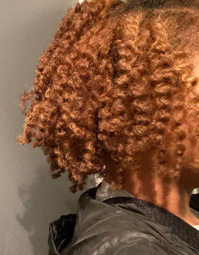 reviewer with curly twist out from a rear-side view