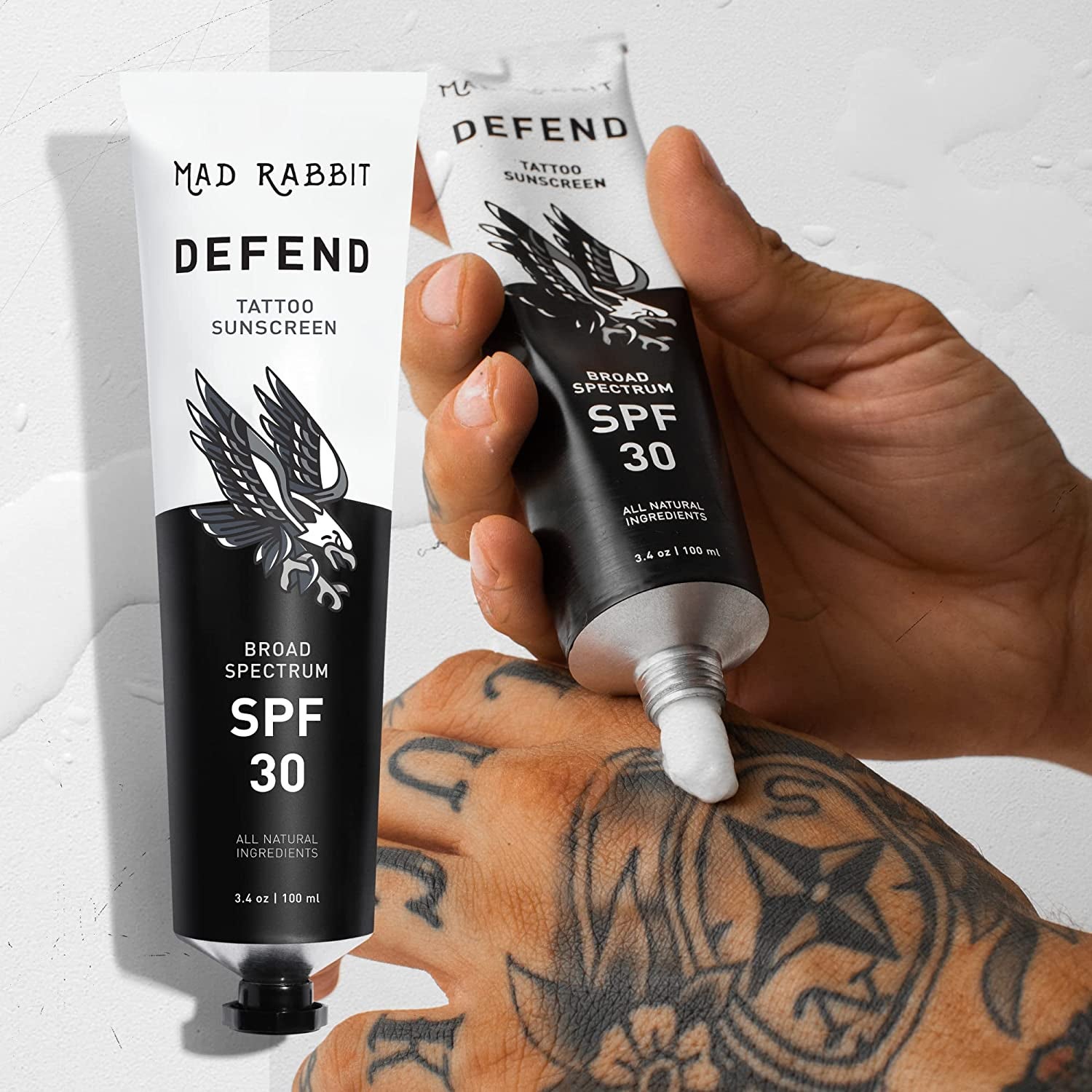 a model applying the sunscreen onto a tatooed hand