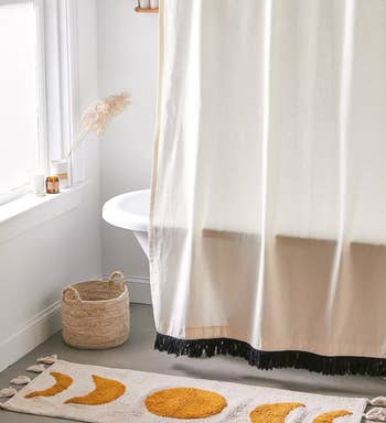 the moon phase bath mat in front of a tub